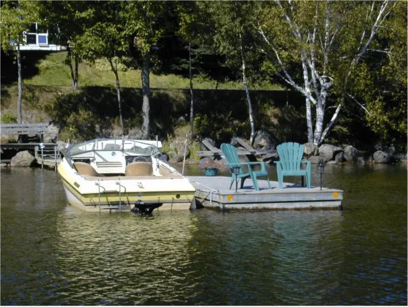 A boat in water next to a dock