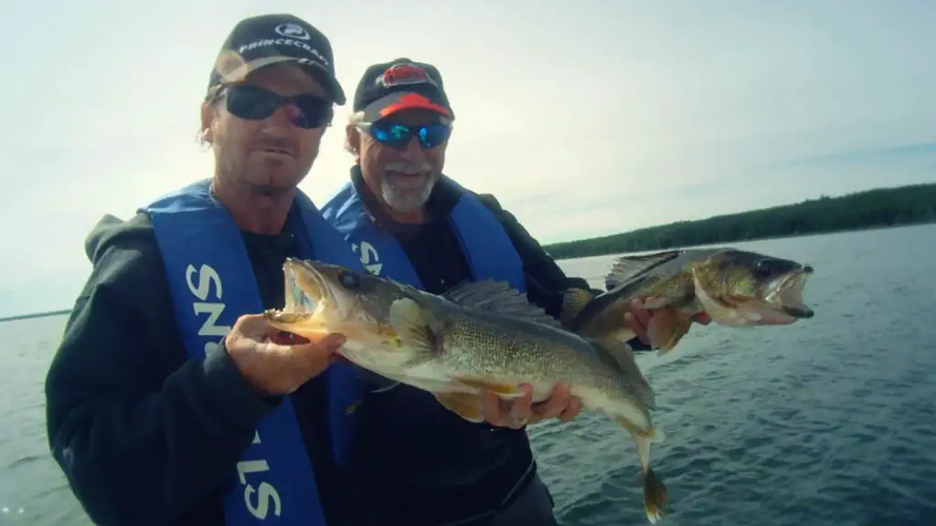 Ang and Pete holding walleye on a lake