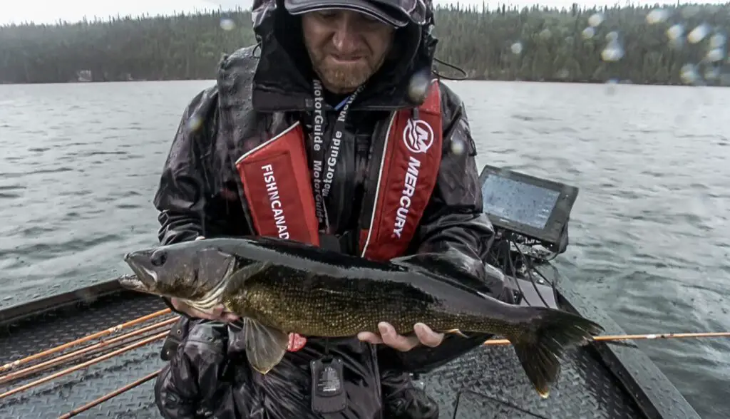 Pete Bowman holding a walleye on a rainy day